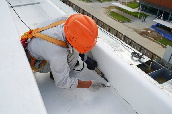 Roofer welding a seam on a PVC roof.