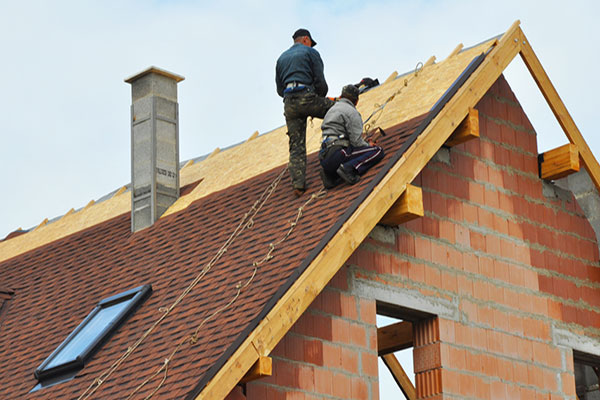 Roofers installing shingles on a steep-slope roof